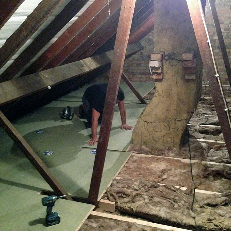 Person fitting Loft boarding over loft insulation