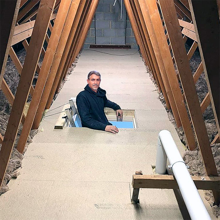 Smiling person coming out of loft hatch